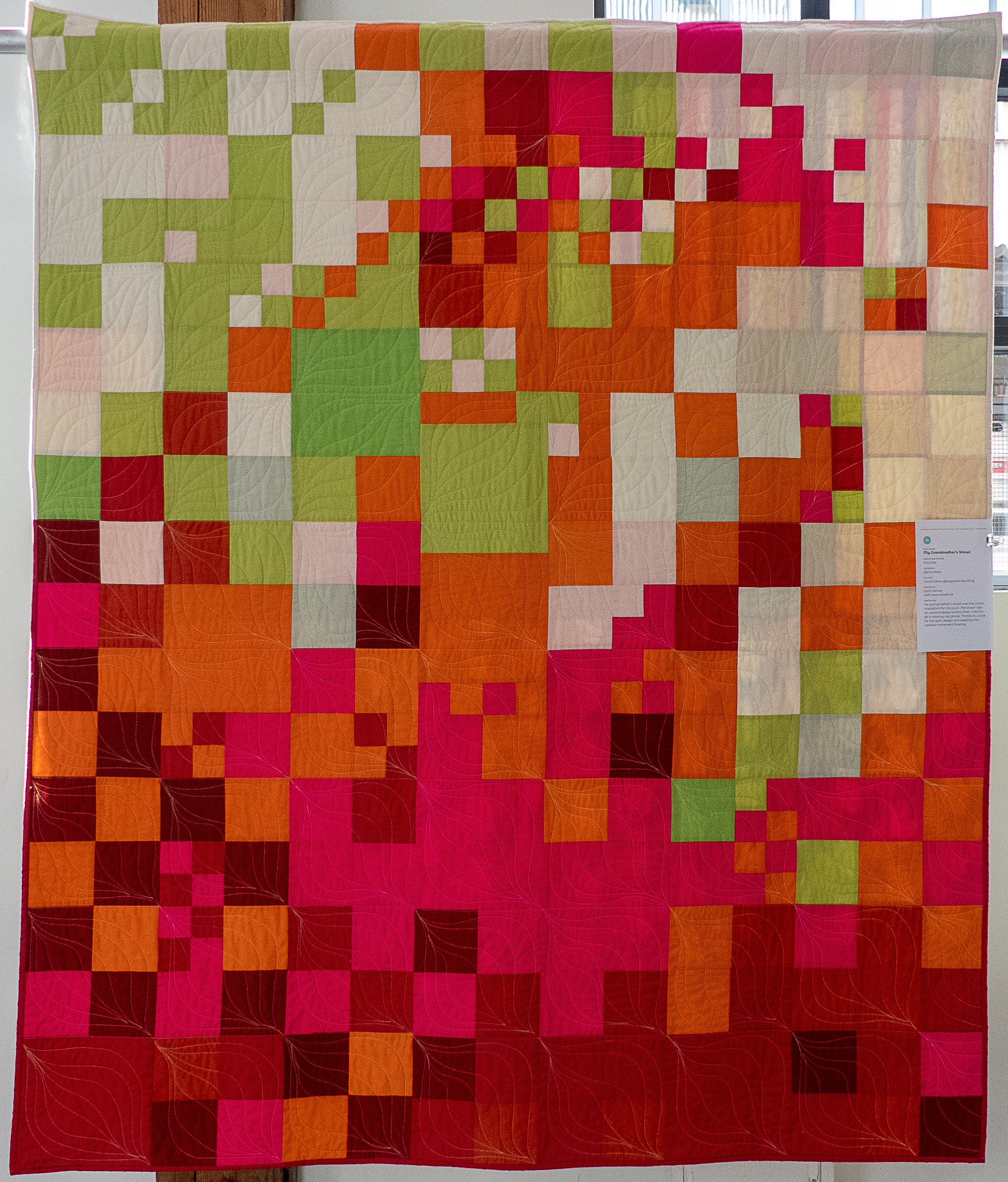 modern quilt using many squares in pink, orange, green, cream and maroon colours