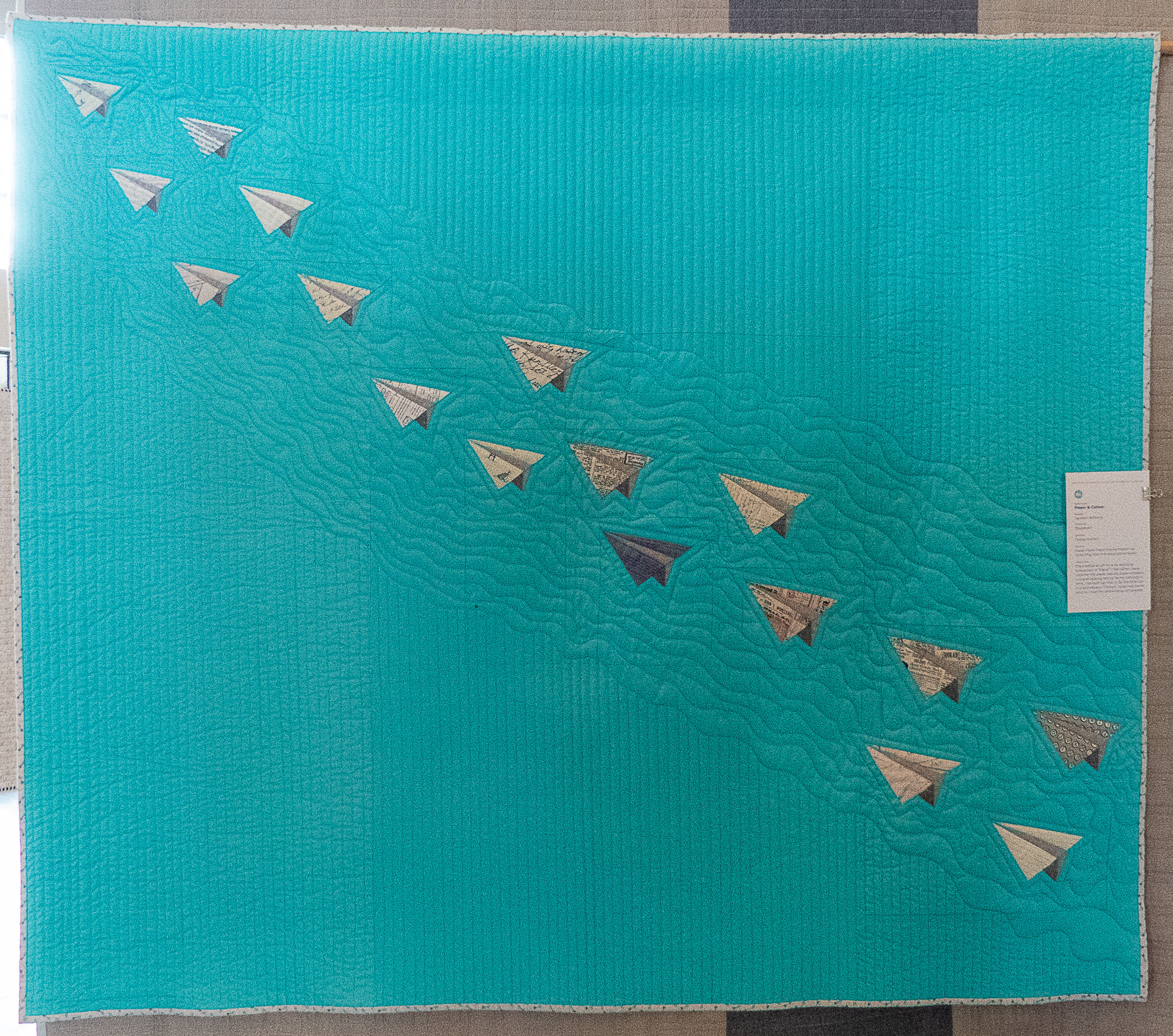 modern quilt containing paper airplane shapes