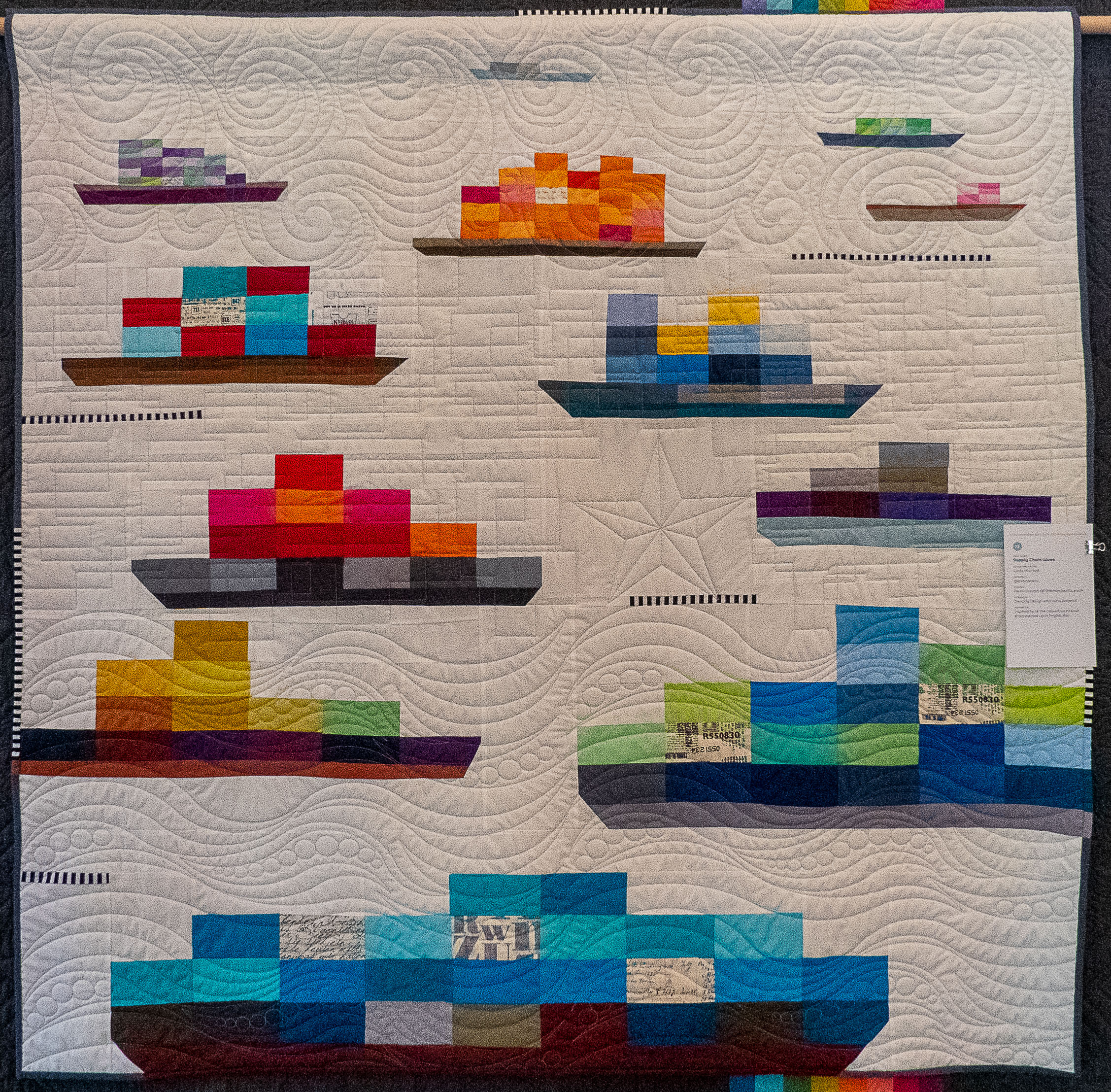 Modern quilt including ships carrying containers made from colourful fabric